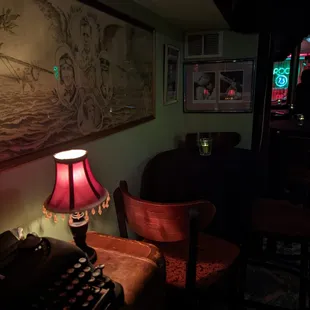 a typewriter and a lamp in a dimly lit room