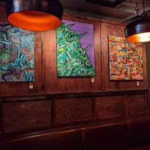 a row of paintings on the wall