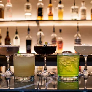 a variety of cocktails on a bar