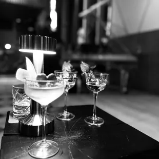 a black and white photograph of a table with glasses and a candle
