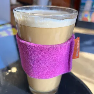 a cup of coffee with a pink felt sleeve
