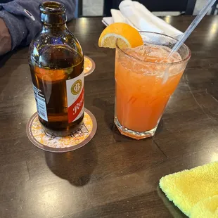 a bottle of beer and a glass of orange juice