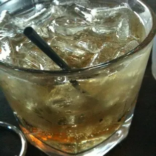 a glass of whiskey with a spoon in it