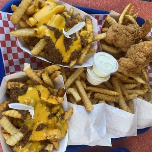Two orders of chili cheese fries and chicken tender meal.