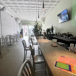 a long bar with chairs and a flat screen tv