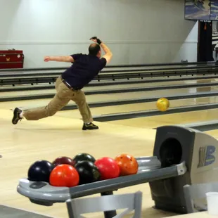 a man throwing a bowling ball