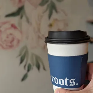 a hand holding a coffee cup