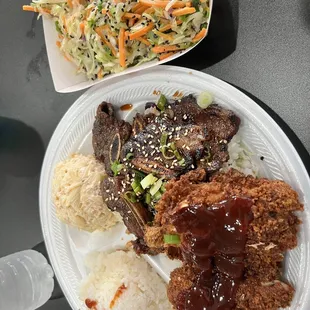a plate of meat, rice, and coleslaw