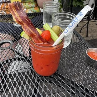 a bloody drink with bacon, tomatoes, and celery