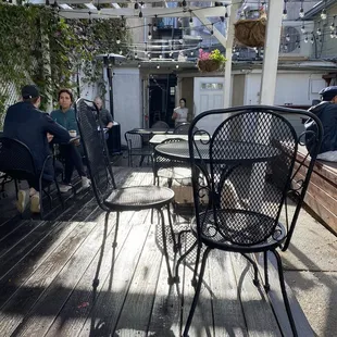 a group of people sitting at tables on a deck