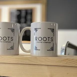 two coffee mugs on a shelf