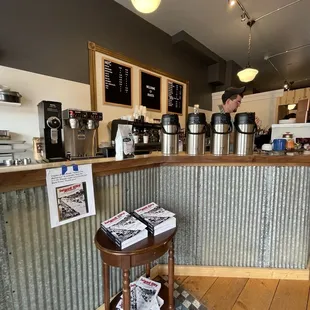 a coffee shop counter with a menu on the wall