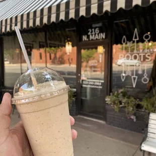 a hand holding a cup of iced coffee
