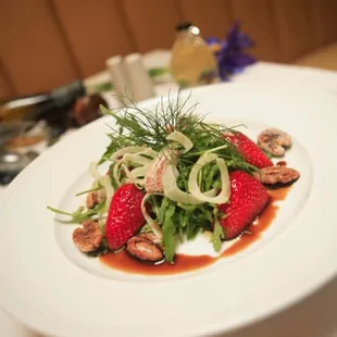 a plate of salad with mushrooms and strawberries