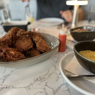 Family style duck fat fried chicken with sides of creamed corn and dirty rice