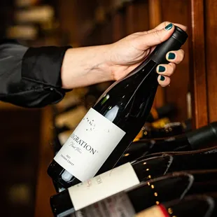 a hand holding a bottle of wine