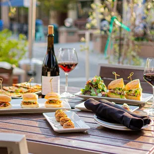 a table with sandwiches and a glass of wine