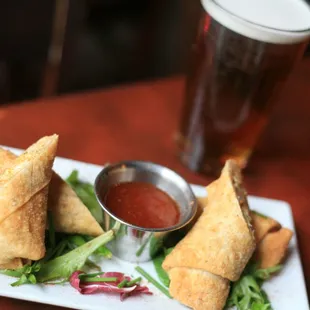 a plate of vegetable spring rolls and a pint of beer