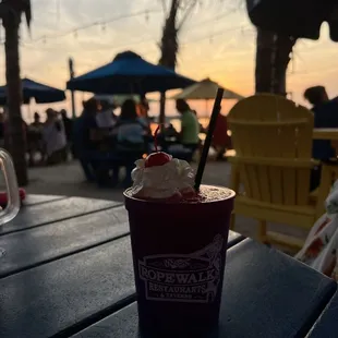 a cup of ice cream and strawberries on a table