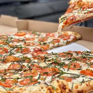 a person taking a slice of pizza