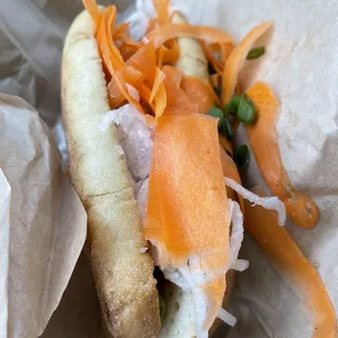 a hot dog with carrots and onions