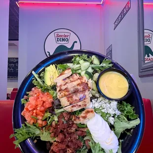 Chicken Cobb Salad, against a photo of the diner interior.