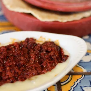 a plate of chili sauce and tortillas