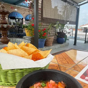 a bowl of salsa and tortillas