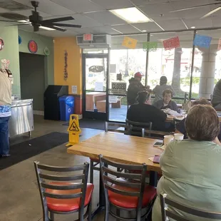 Dining area, shows tables for outside seating past windows.