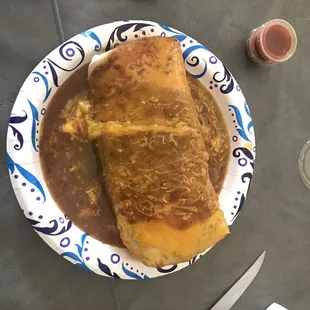 XL Chicken BRC burrito wet, half Green half Red sauce cheese on top.