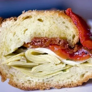 Sandwich consisting of sun dried tomatoes, roasted red peppers, fresh mozz, and artichokes.