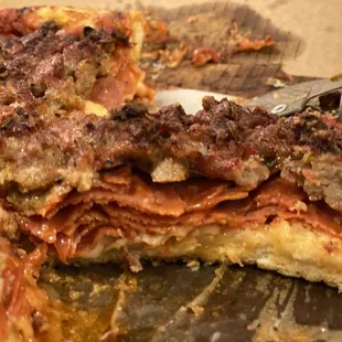 a slice of pizza with meat and cheese