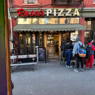 people standing outside of a restaurant