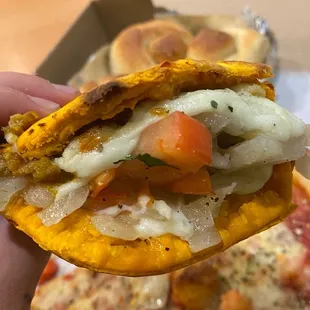 a hand holding a pizza