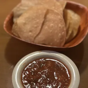a bowl of chili and pita chips