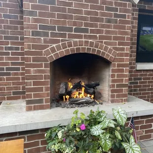 a brick fireplace with a fire in it