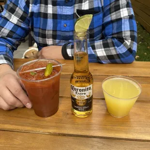 a man sitting at a table with a beer and a bloody drink