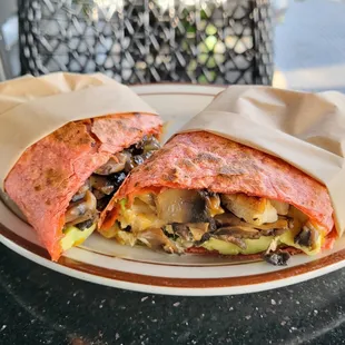 Grilled chicken wrap with sun dried tomato tortilla. Chicken breast,  mushroom, spinach, red onion, avocado, cheddar