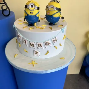 a cake with two minion figurines on top