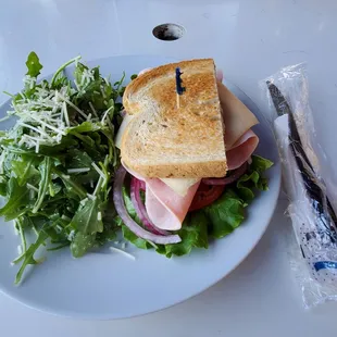 Ham sandwich with side arugula salad