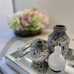 two vases on a mirrored tray