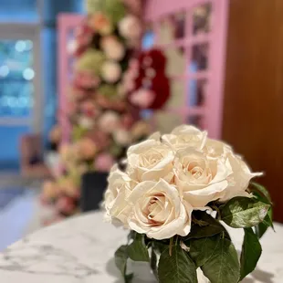 a vase of roses on a marble table