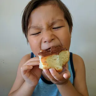 a young boy eating a donut