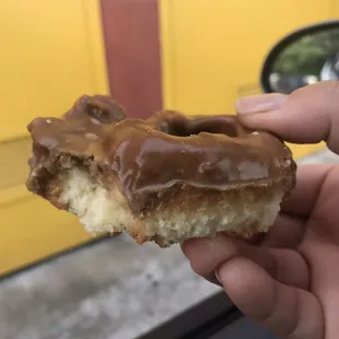 a hand holding a donut