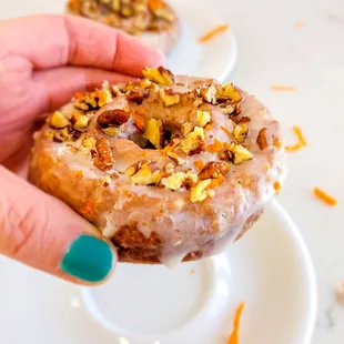 a hand holding a frosted donut
