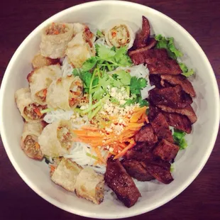 Vietnamese rice noodle bowl made with beef and with also Vietnamese pork eggrolls