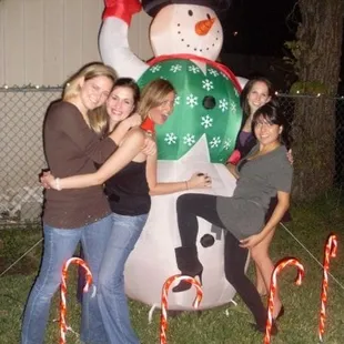 a group of people posing with a snowman