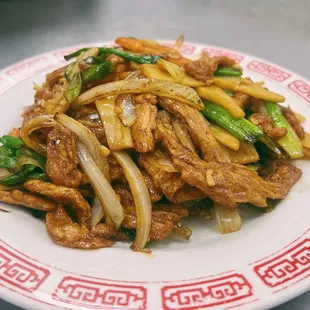 a plate of stir fried beef and vegetables