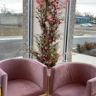 two pink chairs in front of a large window