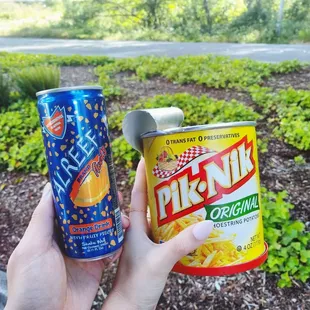 a person holding a can and a drink